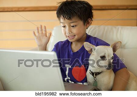 Mixed race boy using laptop and hugging dog View Large Photo Image Stock Image - Mixed race boy using laptop and hugging dog. Fotosearch