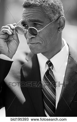 Mixed race businessman adjusting sunglasses View Large Photo Image Stock Image - Mixed race businessman adjusting sunglasses. Fotosearch