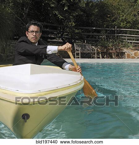Mixed race businessman rowing boat in swimming pool View Large Photo Image Stock Image - Mixed race businessman rowing boat in swimming pool. Fotosearch