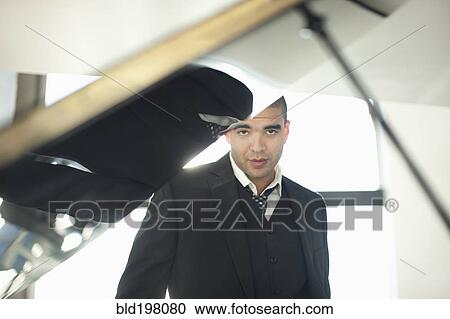 Mixed race businessman standing behind piano View Large Photo Image Stock Image - Mixed race businessman standing behind piano. Fotosearch