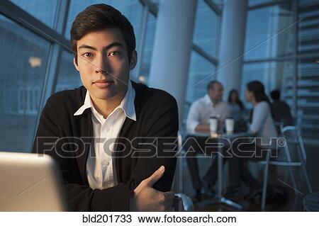 Stock Image - Mixed race businessman using laptop in cafe. Fotosearch