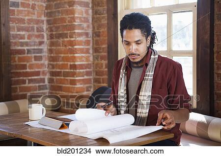 Picture - Mixed race businessman working in coffee shop. Fotosearch