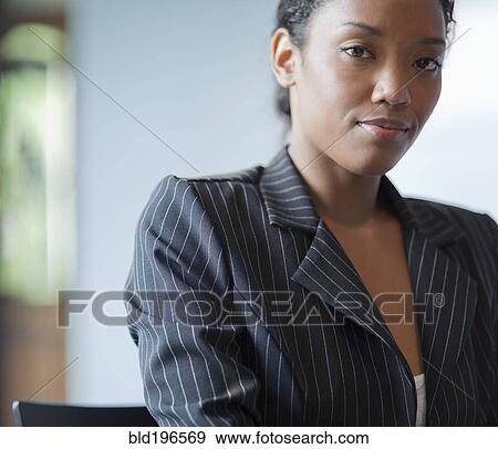 Stock Photo - Mixed race businesswoman sitting at desk. Fotosearch