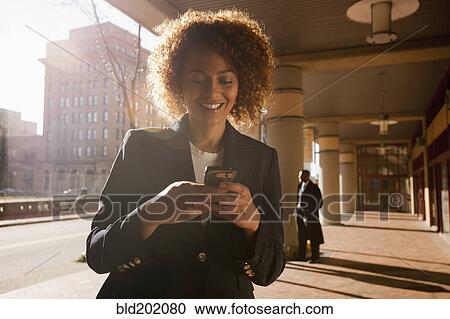 Mixed race businesswoman text messaging on cell phone View Large Photo Image Stock Image - Mixed race businesswoman text messaging on cell phone. Fotosearch