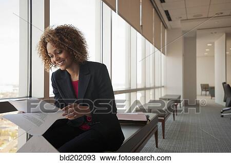 Stock Image - Mixed race businesswoman working in conference room. Fotosearch