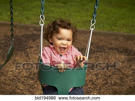 Mixed race child sitting in swing laughing View Large Photo Image Stock Photo - Mixed race child sitting in swing laughing. Fotosearch
