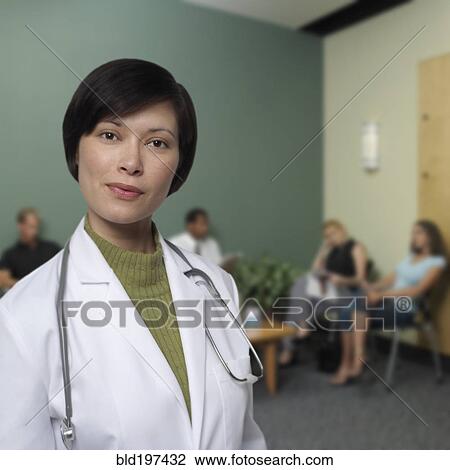 Stock Image - Mixed race doctor standing in waiting room. Fotosearch