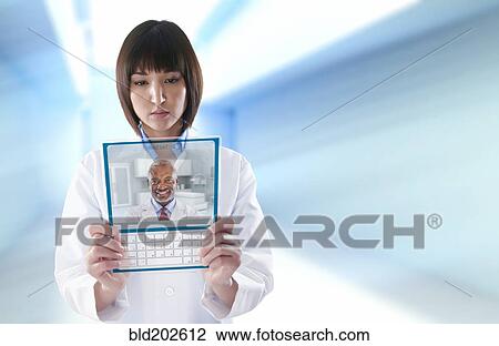 Mixed race doctor using digital tablet View Large Photo Image Stock Image - Mixed race doctor using digital tablet. Fotosearch