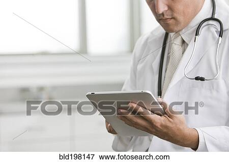 Mixed race doctor using digital tablet View Large Photo Image Stock Photo - Mixed race doctor using digital tablet. Fotosearch