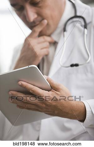Mixed race doctor using digital tablet View Large Photo Image Stock Photo - Mixed race doctor using digital tablet. Fotosearch