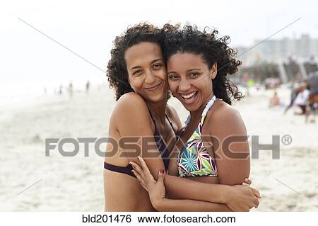Mixed race friends hugging on beach View Large Photo Image Stock Photograph - Mixed race friends hugging on beach. Fotosearch