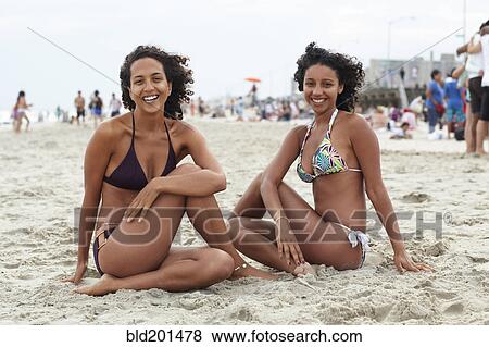 Mixed race friends sitting on beach View Large Photo Image Stock Photo - Mixed race friends sitting on beach. Fotosearch