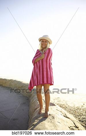 Stock Photograph - Mixed race girl at beach wrapped in towel. Fotosearch