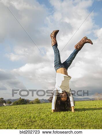 Stock Image - Mixed race girl doing cartwheel. Fotosearch