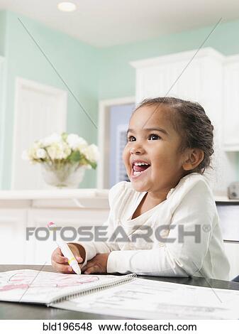 Stock Photo - Mixed race girl drawing in notebook. Fotosearch