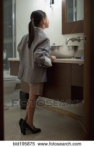 Stock Photography - Mixed race girl dressing up in mother's clothing. Fotosearch