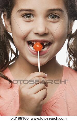 Mixed race girl eating lollipop View Large Photo Image Stock Image - Mixed race girl eating lollipop. Fotosearch