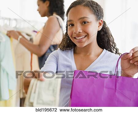 Mixed race girl handing over money in clothing store View Large Photo Image Stock Image - Mixed race girl handing over money in clothing store. Fotosearch