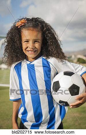 Mixed race girl holding soccer ball View Large Photo Image Stock Photography - Mixed race girl holding soccer ball. Fotosearch