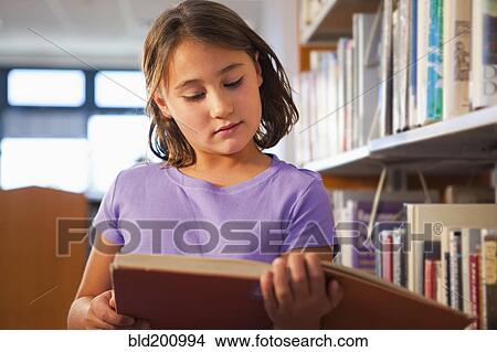 Mixed race girl reading book in library View Large Photo Image Picture - Mixed race girl reading book in library. Fotosearch
