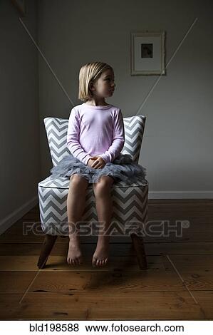 Stock Photo - Mixed race girl sitting on chair. Fotosearch