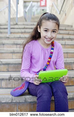 Mixed race girl using digital tablet on staircase View Large Photo Image Stock Photo - Mixed race girl using digital tablet on staircase. Fotosearch