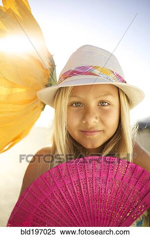 Stock Photography - Mixed race girl with large flower and fan. Fotosearch