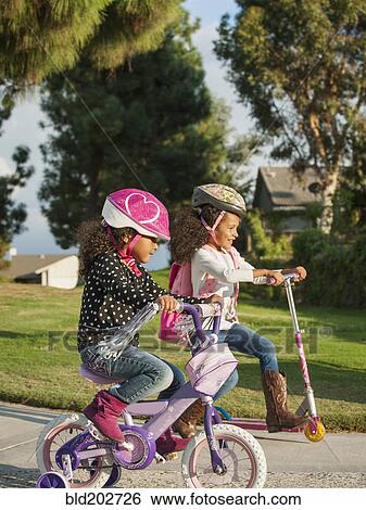Stock Photograph - Mixed race girls playing outdoors. Fotosearch