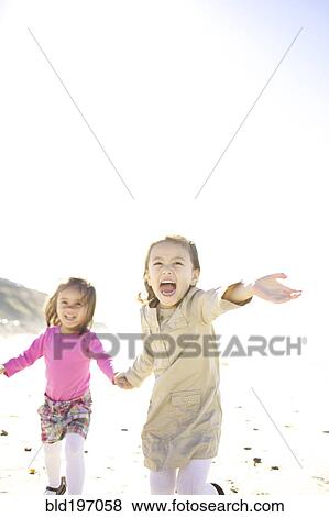 Stock Photo - Mixed race girls running on beach. Fotosearch