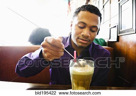 Mixed race man enjoying milkshake in diner booth View Large Photo Image Stock Image - Mixed race man enjoying milkshake in diner booth. Fotosearch