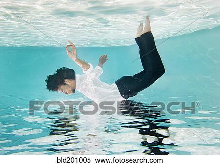 Mixed race man in clothes underwater in swimming pool View Large Photo Image Stock Photography - Mixed race man in clothes underwater in swimming pool. Fotosearch