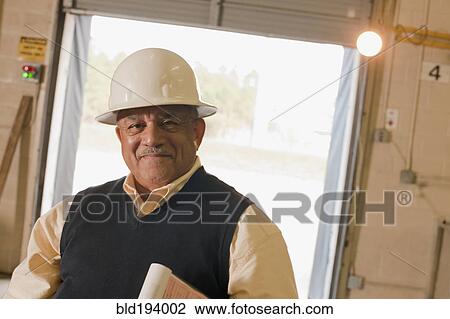 Mixed race man in hard-hat in warehouse View Large Photo Image Stock Image - Mixed race man in hard-hat in warehouse. Fotosearch
