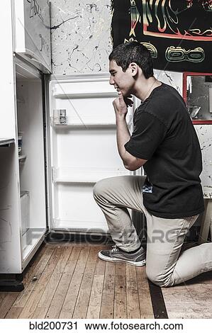 Mixed race man looking in refrigerator View Large Photo Image Stock Image - Mixed race man looking in refrigerator. Fotosearch