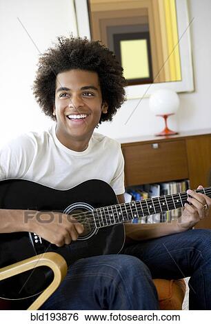 Mixed race man playing guitar View Large Photo Image Stock Photograph - Mixed race man playing guitar. Fotosearch