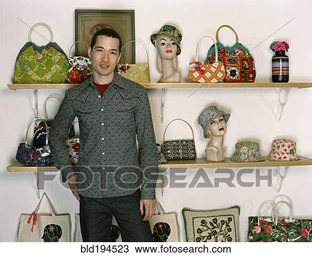 Stock Image - Mixed race man standing in retro purse shop. Fotosearch