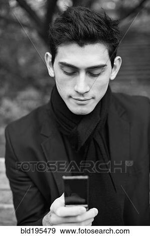 Mixed race man text messaging with cell phone View Large Photo Image Stock Photo - Mixed race man text messaging with cell phone. Fotosearch