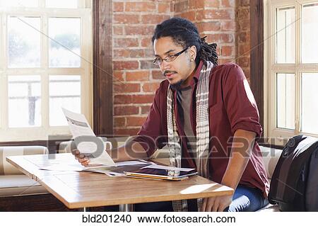Stock Image - Mixed race man working in coffee shop. Fotosearch