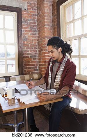 Stock Photograph - Mixed race man working in coffee shop. Fotosearch
