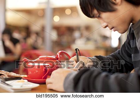 Mixed race man writing at cafe View Large Photo Image Stock Photography - Mixed race man writing at cafe. Fotosearch