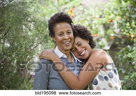 Mixed race mother and daughter hugging View Large Photo Image Stock Photo - Mixed race mother and daughter hugging. Fotosearch