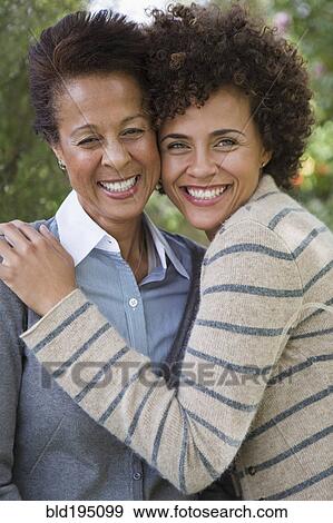 Stock Photo - Mixed race mother and daughter hugging. Fotosearch