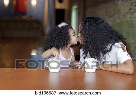 Stock Photo - Mixed race mother and daughter kissing. Fotosearch