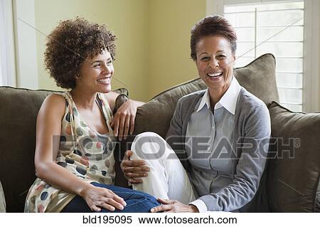 Mixed race mother and daughter sitting on sofa View Large Photo Image Stock Photography - Mixed race mother and daughter sitting on sofa. Fotosearch