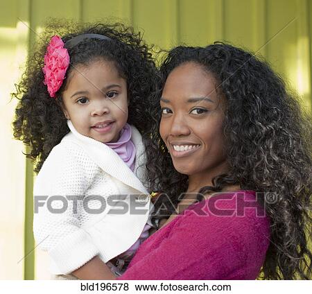 Stock Photo - Mixed race mother and daughter smiling. Fotosearch