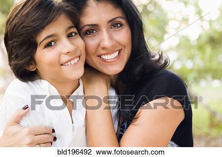 Stock Image - Mixed race mother hugging son. Fotosearch