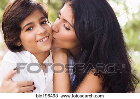 Stock Image - Mixed race mother kissing son. Fotosearch