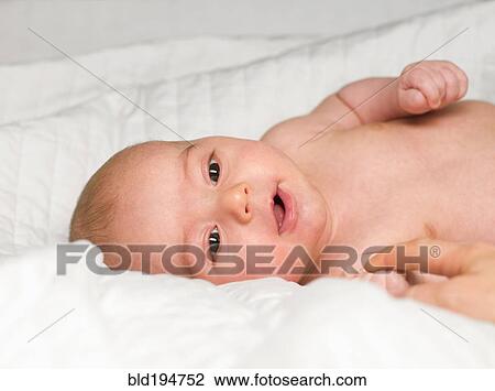 Stock Image - Mixed race newborn baby laying in crib. Fotosearch