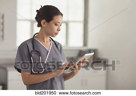 Mixed race nurse using digital tablet View Large Photo Image Stock Image - Mixed race nurse using digital tablet. Fotosearch