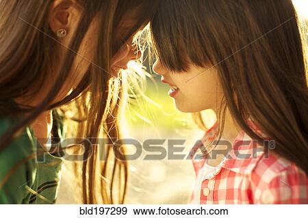 Mixed race sisters looking at one another View Large Photo Image Stock Photo - Mixed race sisters looking at one another. Fotosearch