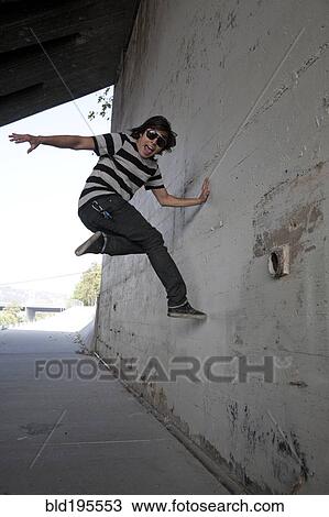 Mixed race teenage boy jumping off wall View Large Photo Image Stock Image - Mixed race teenage boy jumping off wall. Fotosearch